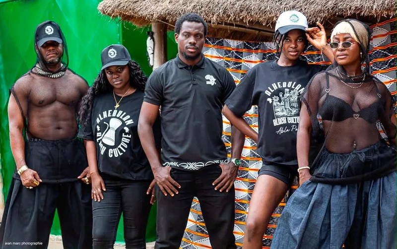 Groupe de cinq modèles en tenues Alkebulan : t-shirts, polo et pièces en résille