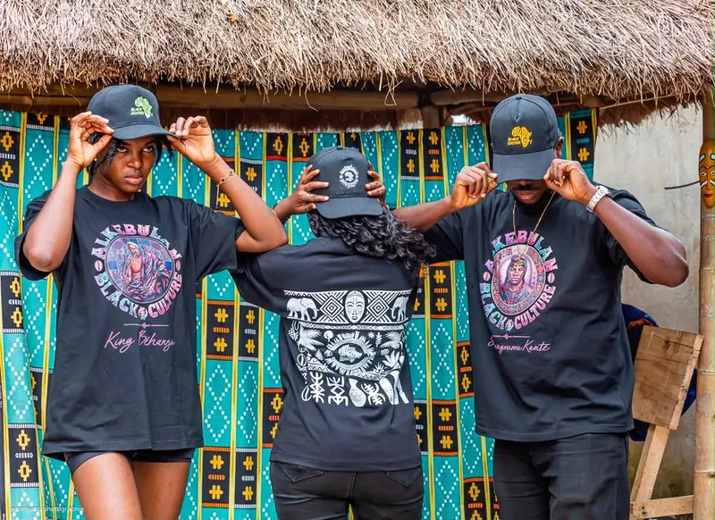 Trois modèles portant les t-shirts King Béhanzin, Soumangourou Kanté et le dos à motifs africains
