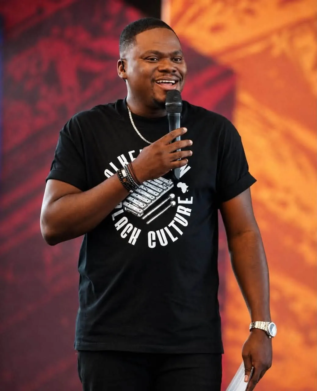 Présentateur en t-shirt Alkebulan sur scène